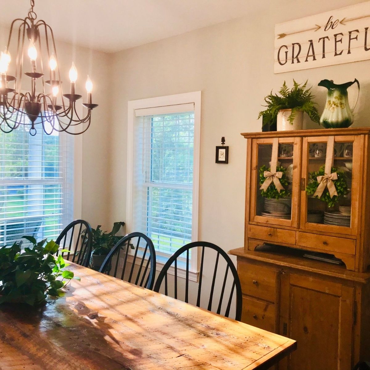 farmhouse wooden table with antique wood hutch and black farmhouse chairs